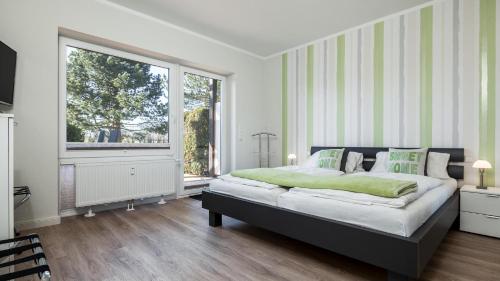 a bedroom with a large bed and a large window at Golfresidenz B 003 in Grömitz