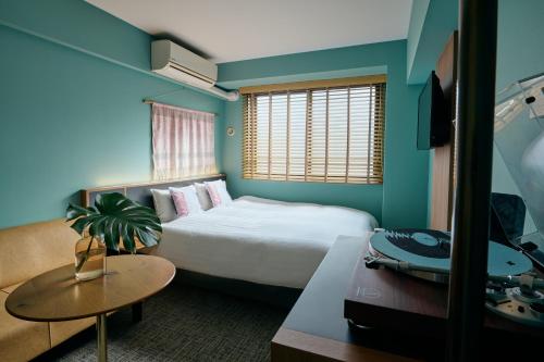 a hotel room with a bed and a table at Hotel She, Kyoto in Kyoto