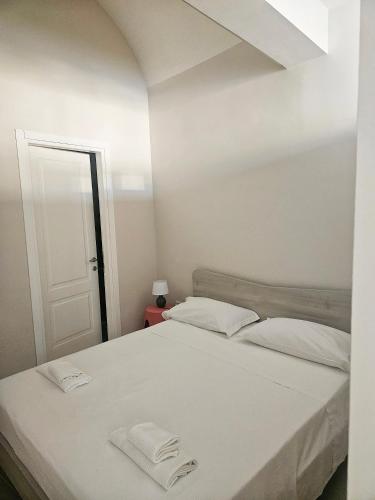 a white bed with two white towels on it at La Guglia - Maison à Porter in Vasto