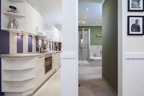 a large kitchen with white counters and a shower at Golfresidenz B 001 in Grömitz