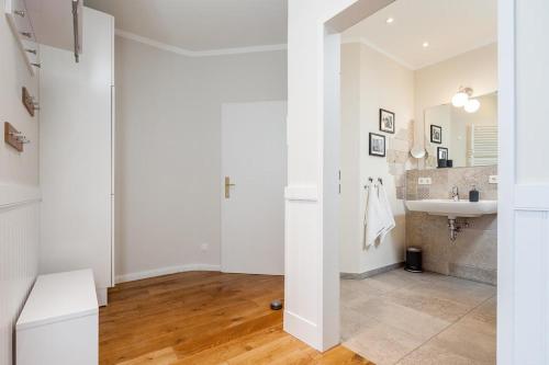 a white bathroom with a sink and a mirror at Golfresidenz B 002 in Grömitz