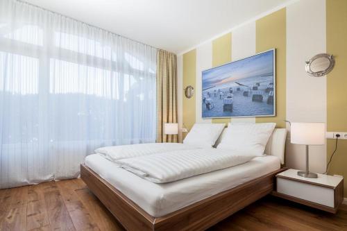a bedroom with a large bed with a large window at Golfresidenz B 002 in Grömitz