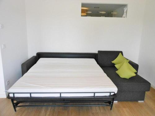 a bed in a room with a black couch at Golfresidenz D 1 03 in Grömitz