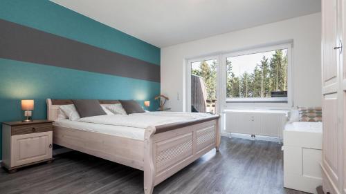 a bedroom with a bed and a blue wall at Golfresidenz B 105 in Grömitz