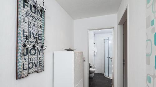 a bathroom with white walls and a white refrigerator at Golfresidenz B 105 in Grömitz