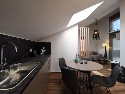 a kitchen with a table and chairs and a living room at Athenean Rooftop Nest in Athens