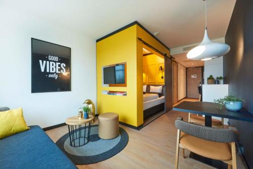 a living room with a blue couch and a yellow wall at Cityden Zuidas in Amstelveen