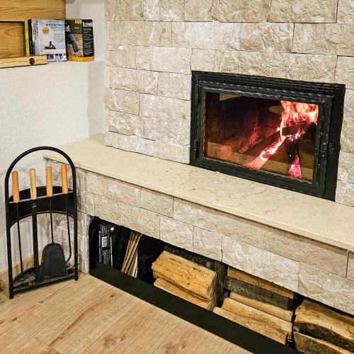 a stone fireplace with a fire in it at Vikendica 937 Lux & Spa, Istočno Sarajevo, Pale, Jahorina i Sarajevo na 15km in Pale