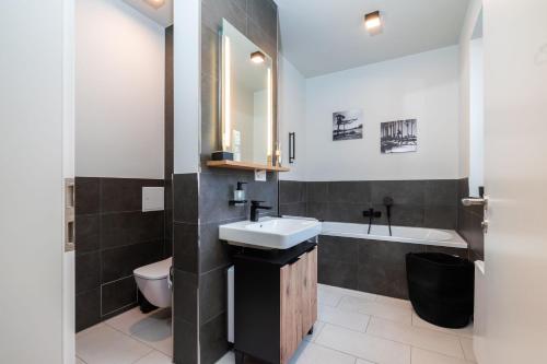a bathroom with a sink and a toilet and a tub at Laras Loft in Leipzig