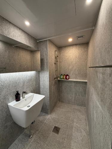 a bathroom with a white sink and a shower at DADA Stay Hongdae in Seoul