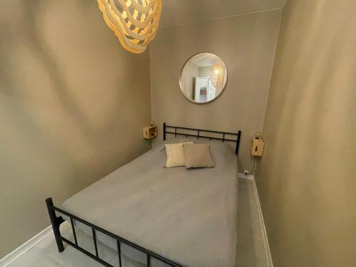 a small bedroom with a bed and a mirror at Appartement - Bonamour in Capbreton