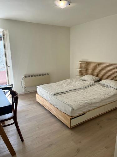 a bedroom with a bed and a chair and a window at Ferienhaus in Piazzogna in Gambarogno