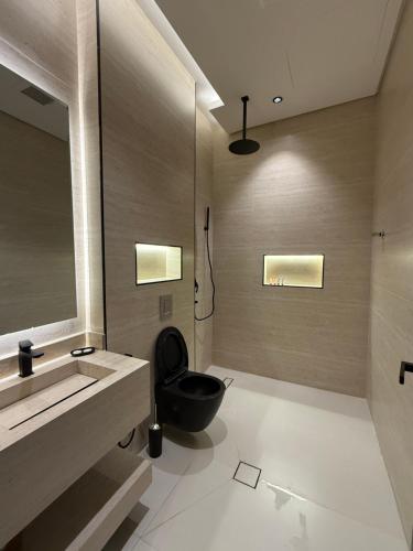 a bathroom with a black toilet and a sink at شاليه جازلي in Riyadh