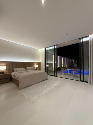 a bedroom with a large bed and large windows at شاليه جازلي in Riyadh