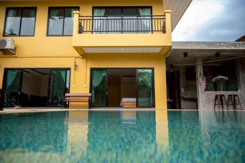 a house with a swimming pool in front of a house at Baanphet Sukphrom Wang Nam Khiao in Ban Khlong Ta Sang