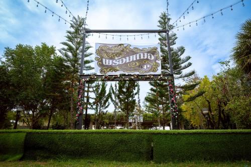 a large sign in a park with christmas lights at Baanphet Sukphrom Wang Nam Khiao in Ban Khlong Ta Sang