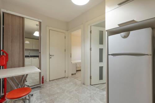 a kitchen with a white refrigerator and a red stool at Premium Rezidans Otel in Antalya