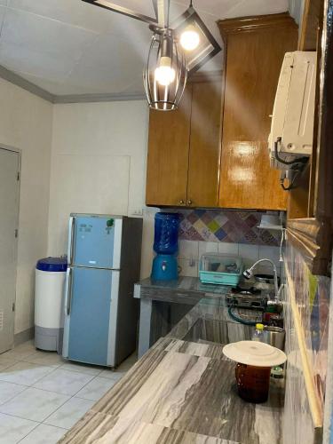 a kitchen with a refrigerator and a table in it at Cebu Cozy Affordable Transient Room Wifi Netflix Shower Heater in Cebu City