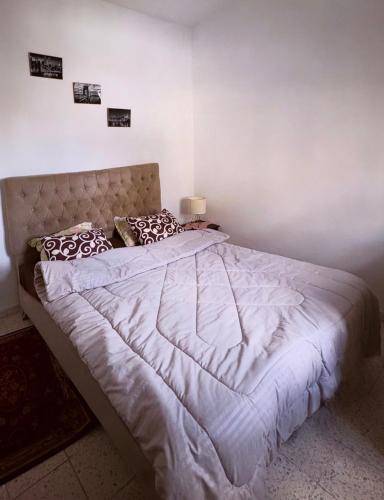 a bedroom with a large bed with white sheets and pillows at Appartement Ettahrir in Tunis