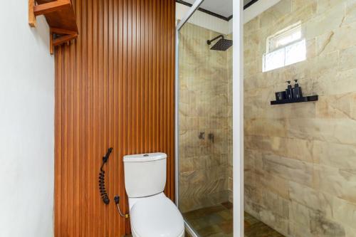 a bathroom with a toilet and a shower at Cabin Linggayoni dieng in Diyeng