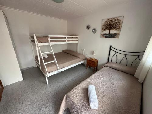 a bedroom with two bunk beds and a ladder at La Marquesa - CA L'ONA in Poblenou del Delta