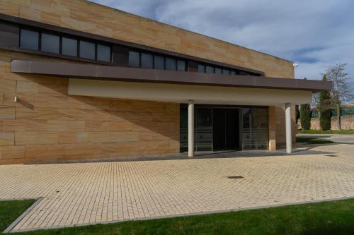 a brick building with a large door in front at Los Claustros de Ayllón in Ayllón