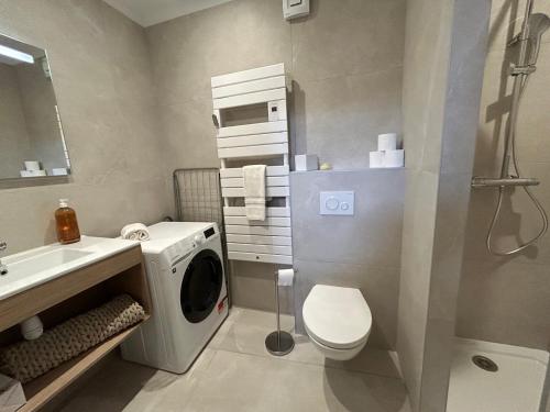 a bathroom with a washing machine and a sink at Clos des Mouliniers - Gîtes 5 étoiles en Ardèche in Saint-Privat