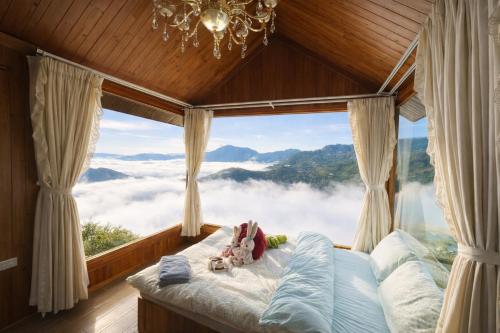 a bedroom with a bed in front of a large window at Xìu Homestay Tà Xùa in Bắc Yên