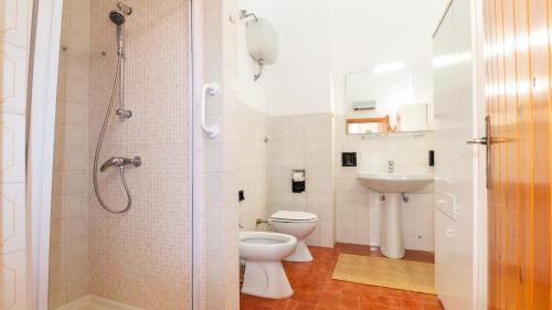 a bathroom with a shower and a toilet and a sink at S'Archittu Sunset House in S'archittu Cuglieri