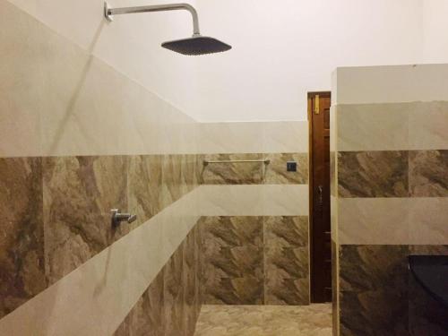 a bathroom with a shower with a glass door at Villa viverra in Polonnaruwa
