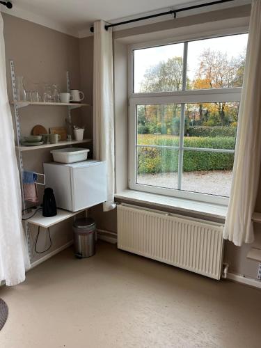 a bathroom with a window and a sink and a toilet at Rinkenæshus Das kleine Zimmer in Gråsten