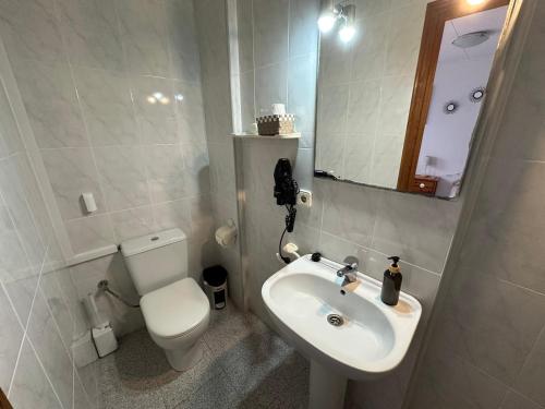a bathroom with a sink and a toilet and a mirror at La Marquesa - CA L'ONA in Poblenou del Delta
