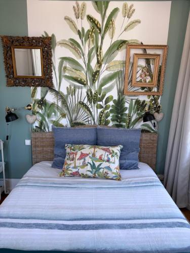 a bedroom with a bed with a large plant on the wall at Le toit de Veules - Proche Mer - Veules les Roses in Veules-les-Roses