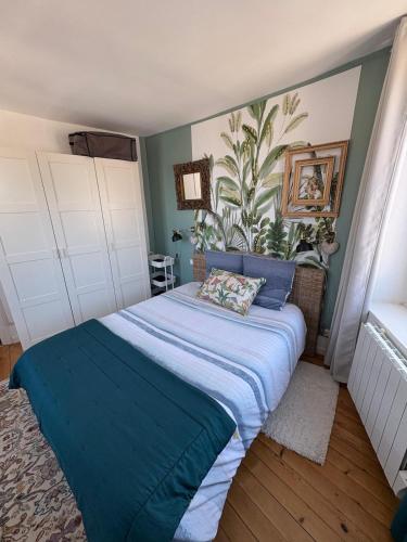 a bedroom with a large bed with a blue blanket at Le toit de Veules - Proche Mer - Veules les Roses in Veules-les-Roses