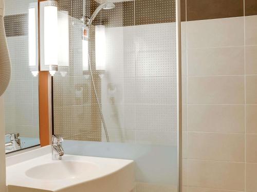 a bathroom with a sink and a glass shower at ibis Salon de Provence in Salon-de-Provence