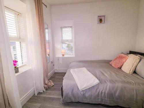 a bedroom with a bed and two windows at San Antonio in Dungloe