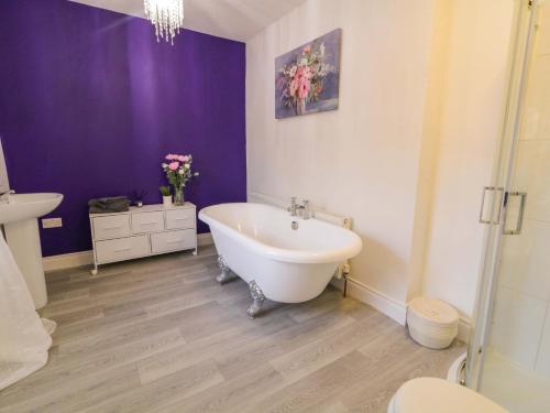 a bathroom with a white tub and a purple wall at San Antonio in Dungloe