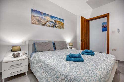 a bedroom with a bed with blue towels on it at Modern 3-bedroom apartment Pieta in Tal-Pietà