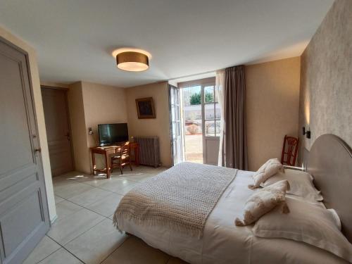 a bedroom with a large bed and a television at Chambre D’hôtes Parc Johan in Chauffailles
