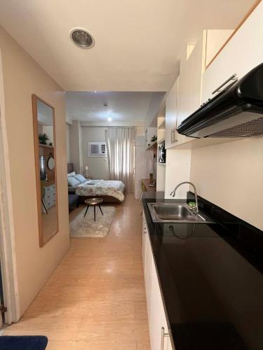 a kitchen with a sink and a living room at Sunvida Tower - Cebu Stay Rental in Dita