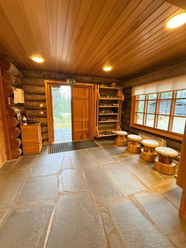 a cabin with a room with stools and a door at KunnonKolo in Luosto
