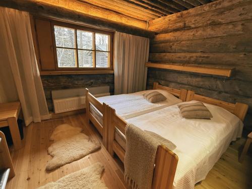 a bedroom with a bed in a log cabin at KunnonKolo in Luosto