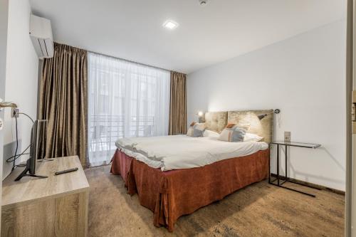 a bedroom with a large bed and a large window at HOF Apartments in Kaunas