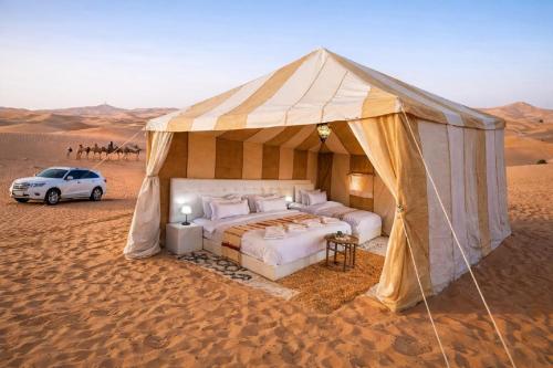 a tent in the desert with a car in it at Jumeria Grand Luxury Desert Resort & Camp in Jaisalmer