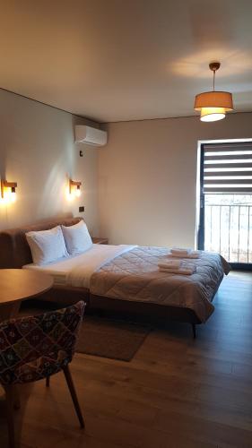 a bedroom with a bed and a table and a window at Немирівель in Nemirov