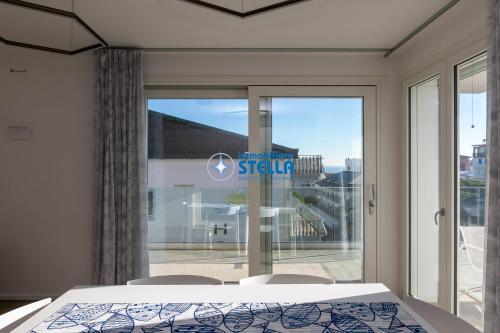 a bedroom with a bed and a large glass window at Condominio Medusa in Lido di Jesolo