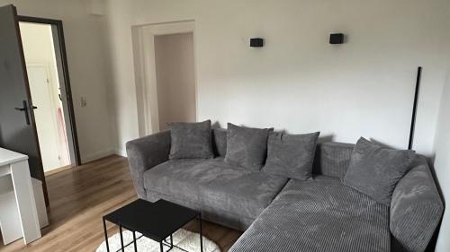 a living room with a gray couch and a table at Am Gebirgsbad in Kurort Jonsdorf
