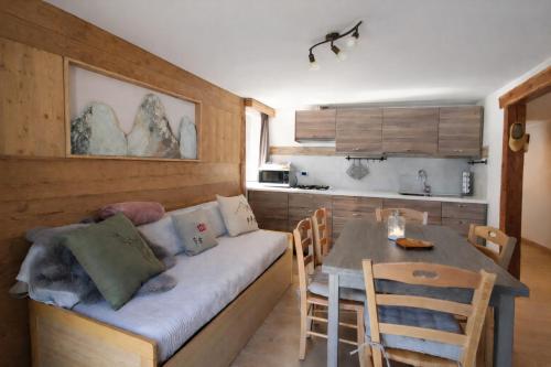a living room with a couch and a dining room table at Appartamento Alta Valle Maira - Provenzale in Villaro