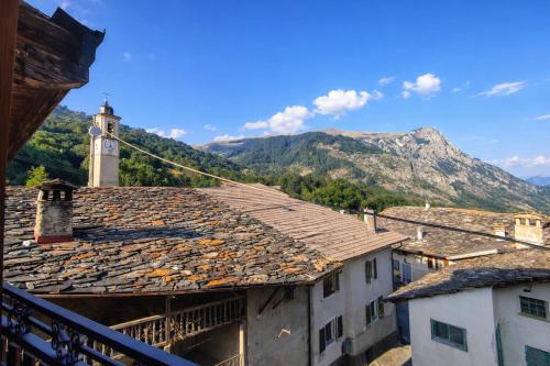 a view of a town with a clock tower and mountains at Appartamento Alta Valle Maira - Provenzale in Villaro