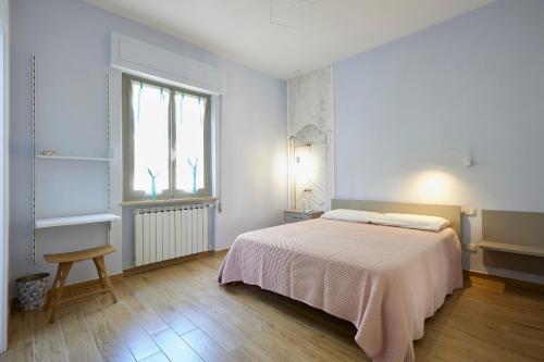 a white bedroom with a bed and a window at La Camelia Bianca B&B in Lerici